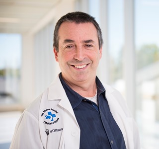 a person in a white lab coat standing in front of a window