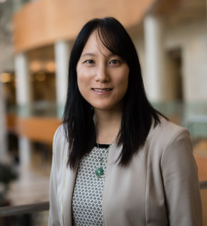 a person in a suit and necklace standing in a lobby