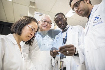 a group of people in lab coats looking at an image