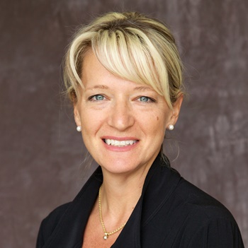 a person in a black jacket and gold necklace