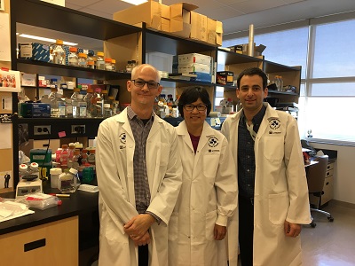 trois personnes dans des manteaux de labo