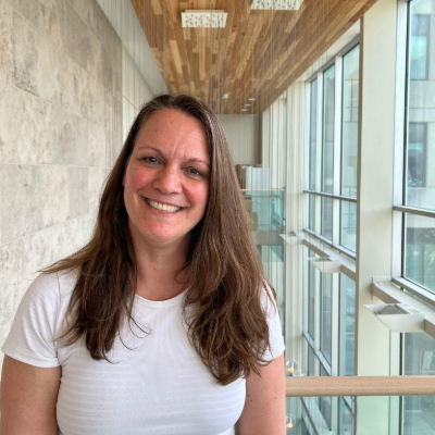 une personne dans une chemise blanche debout devant une fenêtre