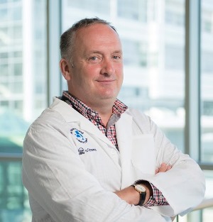 a person in a lab coat standing in front of a window