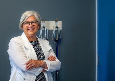 A woman in a white coat stands in a clinic.