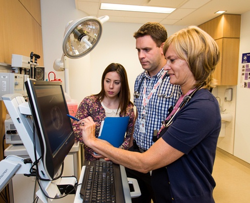 thre people looking at a computer