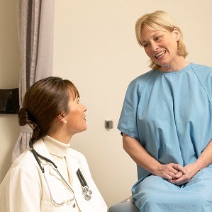 a person in a hospital room talking to a doctor