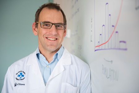 a person in a lab coat standing in front of a whiteboard