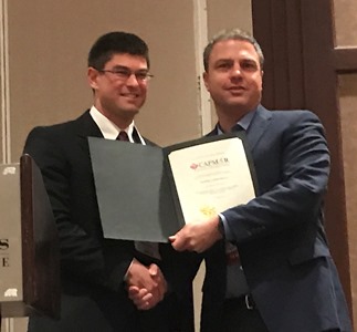 two people in suits and ties holding a certificate