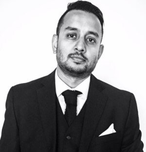 a person in a suit and tie standing in front of a white background