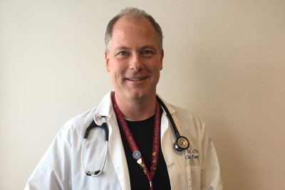 a person in a white coat and black shirt