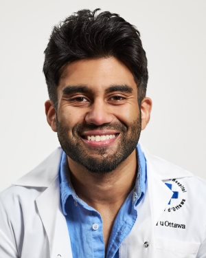 a person in a white lab coat smiles at the camera
