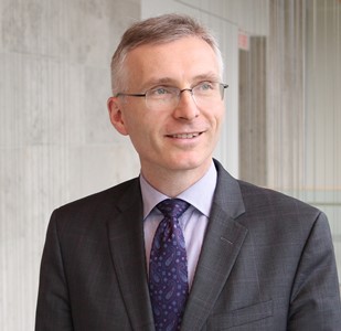 a person in a suit and tie standing in front of a wall