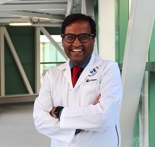 a person in a lab coat standing in front of a green wall