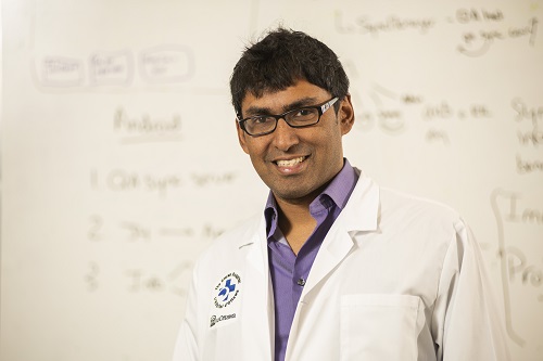 a person in a lab coat standing in front of a whiteboard