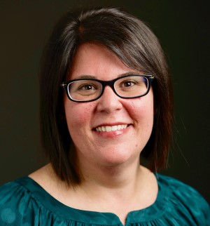 a person in glasses and a green top