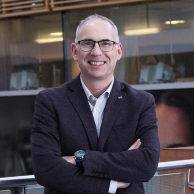 a person in a suit and tie standing with their arms crossed