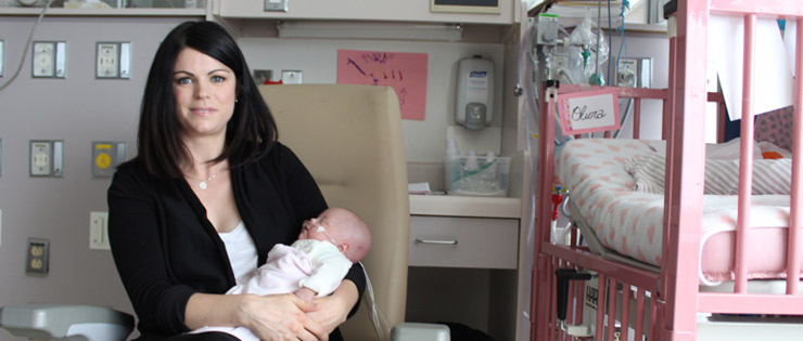 une personne tenant un bébé dans une chambre d'hôpital