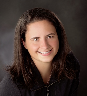 a person in a black jacket smiling at the camera