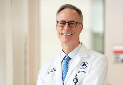 a person in a white lab coat and tie