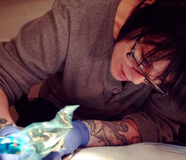 a person with tattoos is getting their tattoo done