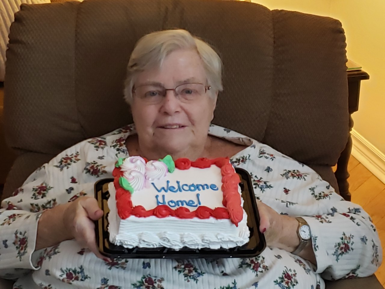 a person sitting in a chair holding a cake