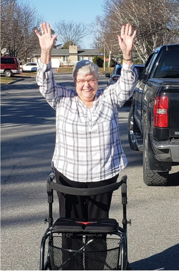 a person in a wheelchair waving at the camera