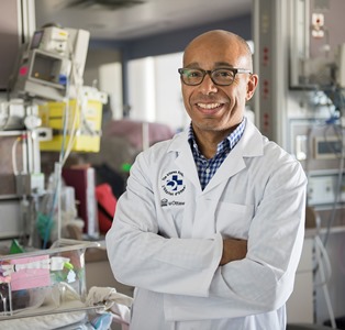 a person in a lab coat standing in front of a table