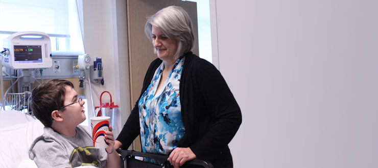 une personne dans une salle d'hôpital qui parle à un garçon