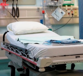 a hospital bed with a blue blanket on it