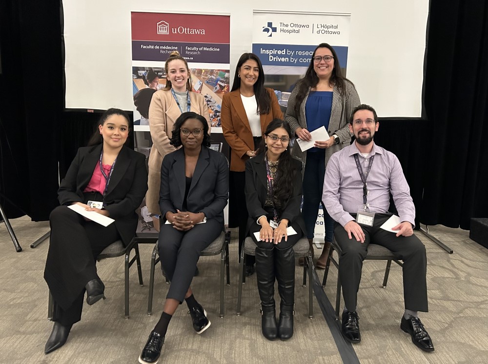 a group of people sitting in chairs in front of a banner