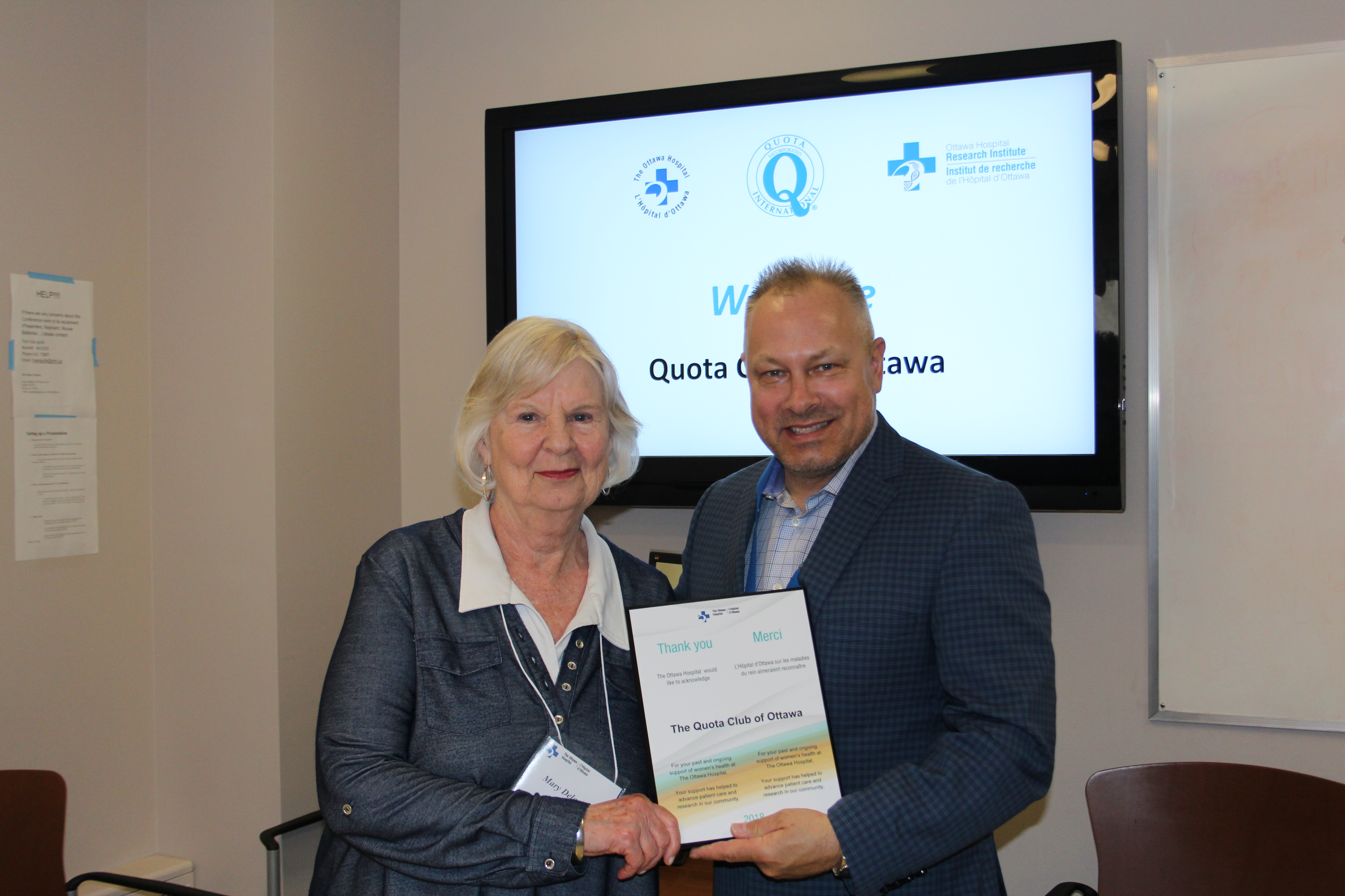 Two people holding a plaque