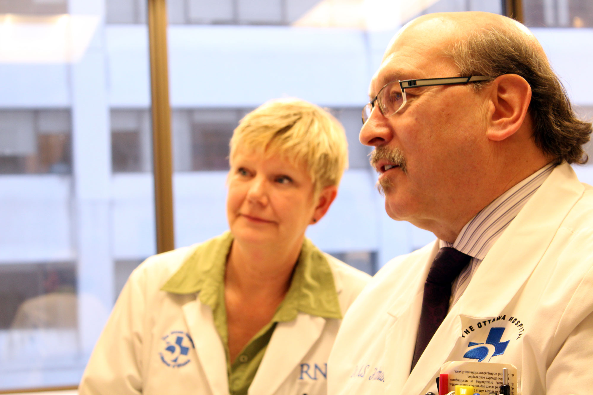 two individuals in  a labcoat in a clinical or office setting