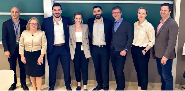 Members of the Blueprint team standing in front of a green wall