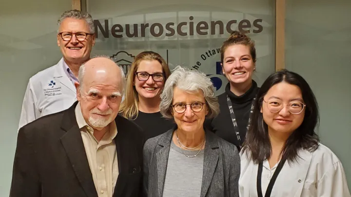 A group of people stand in front of a glass window