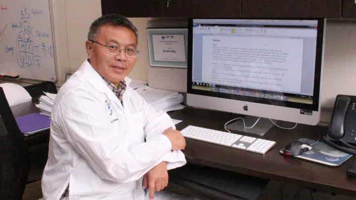 Man sits at a desk with a computer