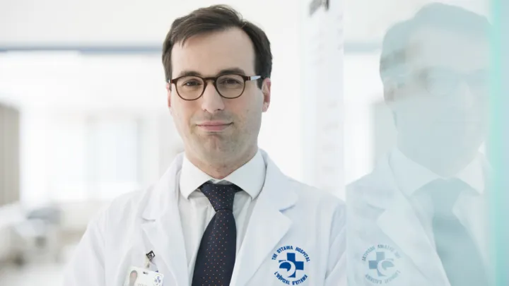 Man in lab coat looks at camera