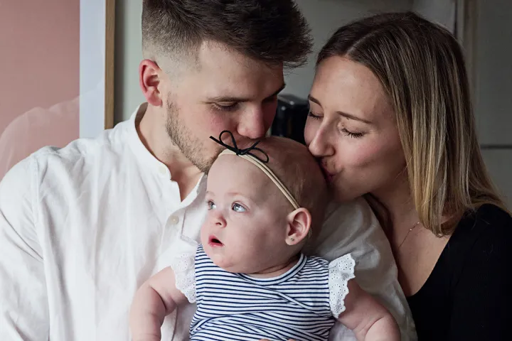 Two parents holding a baby
