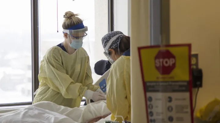 Nurses care for a patient in the ICU