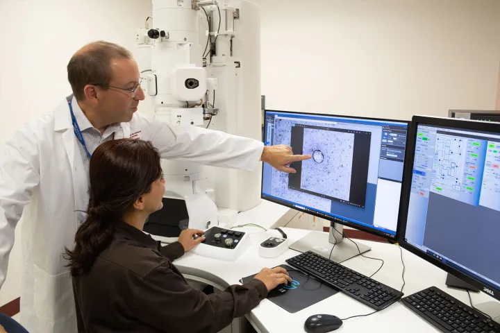 Two people look at a computer screen in a lab
