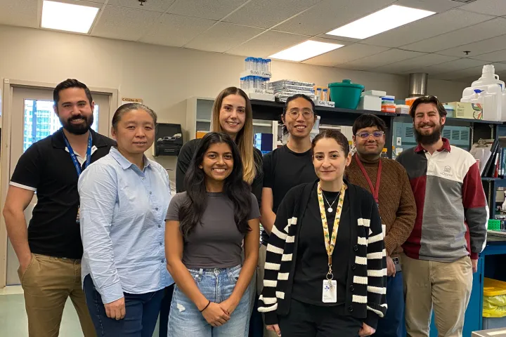 A group of people pose for a photo in a lab