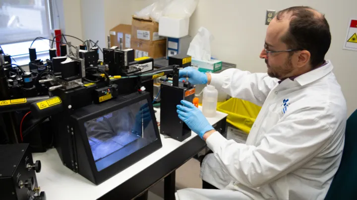 Man in lab coat operates a flow cytometer