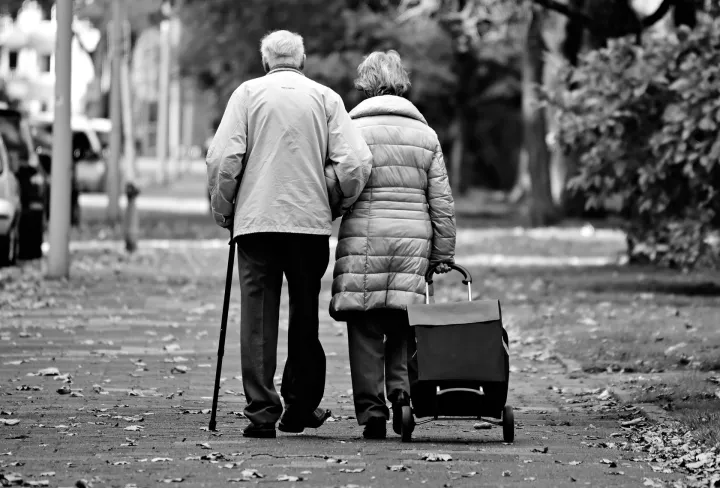 Two elderly people walking outside