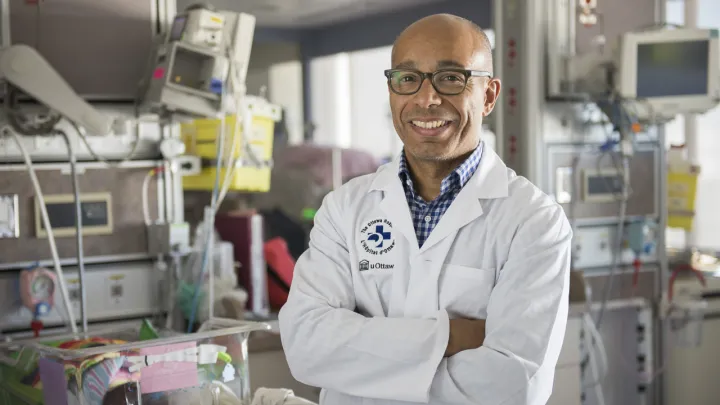 Man in lab coat stands in NICU