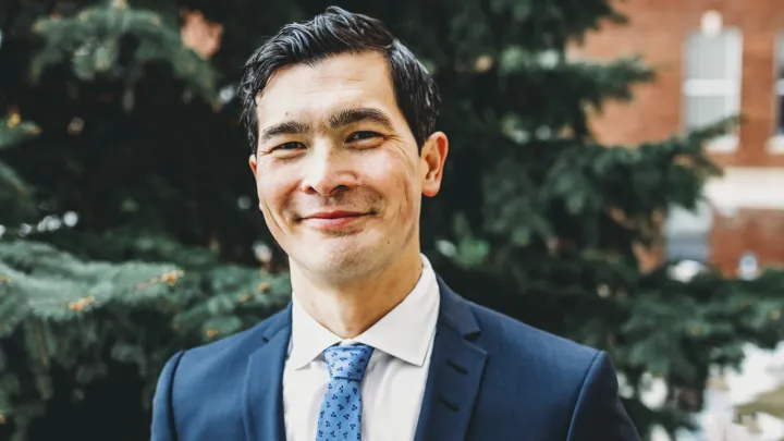 Man in suit smiles at camera