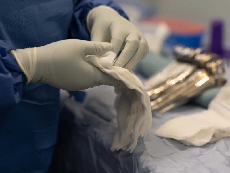 Mains gantées dans une salle d'opération