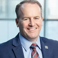 A man in a suit smiling