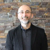 Man in jacket smiles at camera