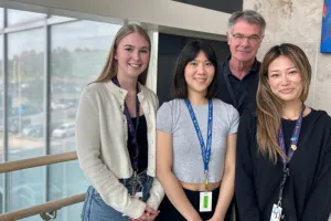 Four people stand and smile