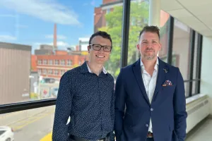 Two men stand together in the hallway of a hospital