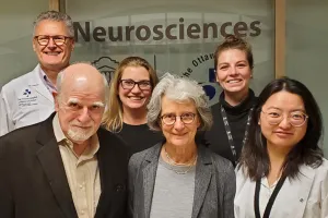 A group of people stand in front of a glass window